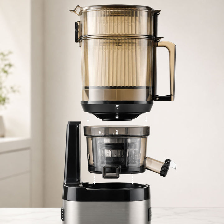 A modern kuvings cs800 slow juicer with a translucent amber-brown upper chamber, black and stainless steel base, and clear lower container, shown on a light countertop in a bright indoor setting.