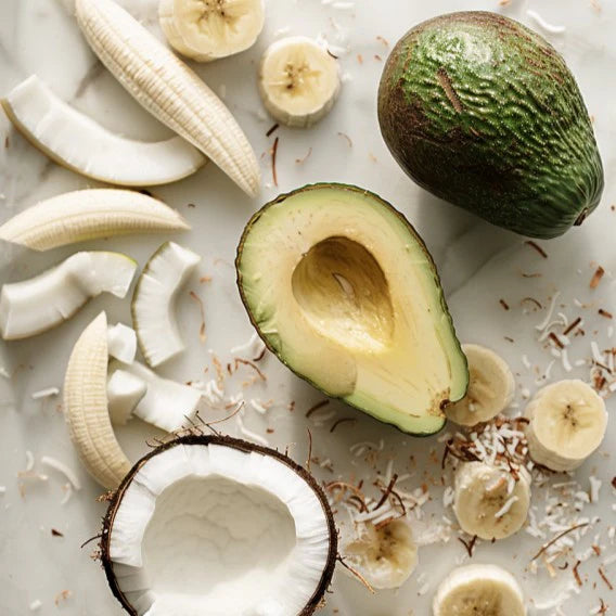 Ingredience na smoothie Kuvings s avokádem, banány a kokosy na světlém povrchu pro recepty na zdravé domácí šťávy a smoothies.