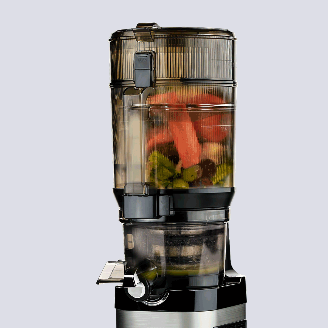 kuvings cs800 in use on a white bacground showing fruit and veg juicing