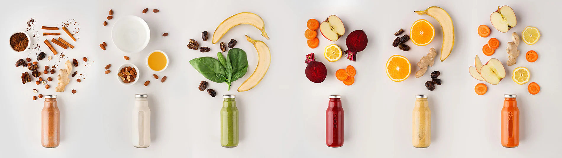 Kuvings kaltgepresster Immune Booster mit Früchten, Nüssen und angeordneten Saftflaschen