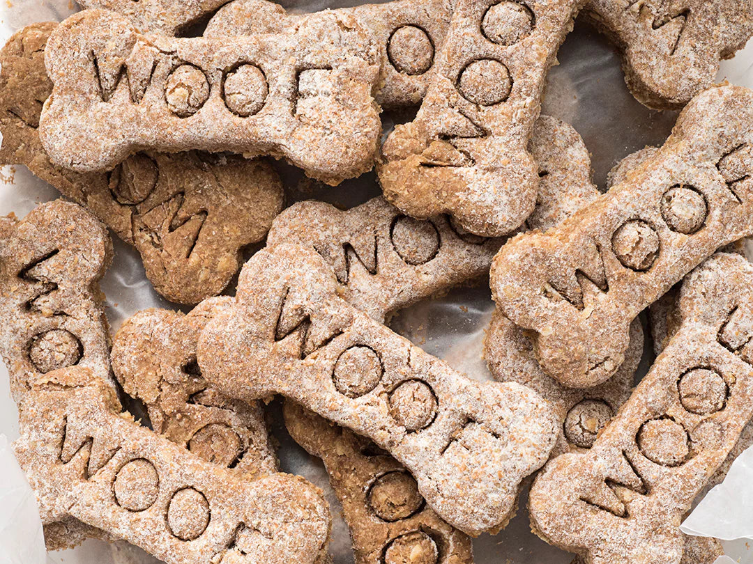 Psí pamlsky ve tvaru kostí s nápisem 'WOOF' vyrobené z dužiny Kuvings.