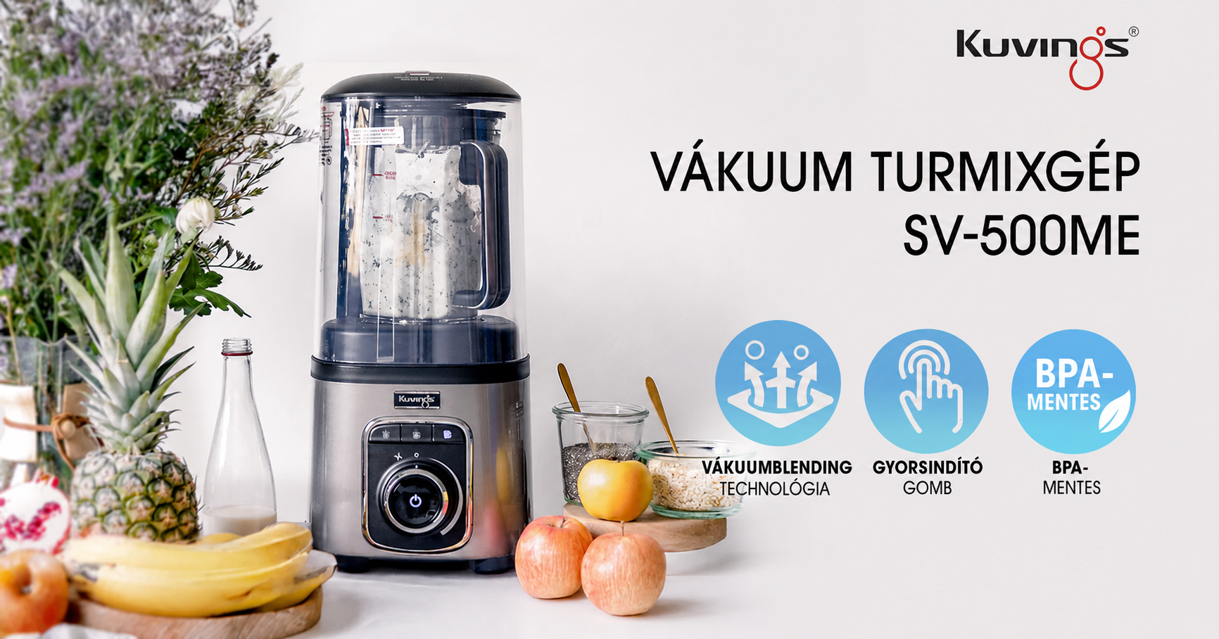 Straight-on view of a marketing banner for the Kuvings SV-500ME vacuum blender, showcasing the appliance on a white surface surrounded by fresh fruits, a bottle, and jars of seeds, alongside Hungarian text and three blue icons highlighting its key features.